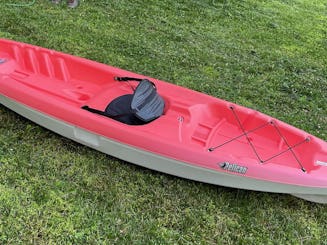 Kayak rouge vif de 10 pieds assis sur le dessus, idéalement situé près de la rivière Brandywine