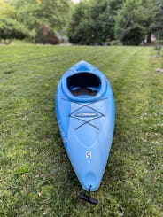 Elegante kayak azul de 9 pies para sentarse dentro ubicado cerca del río Brandywine