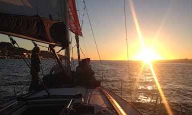 Cruzeiro à vela ao pôr do sol no rio Tejo, Lisboa