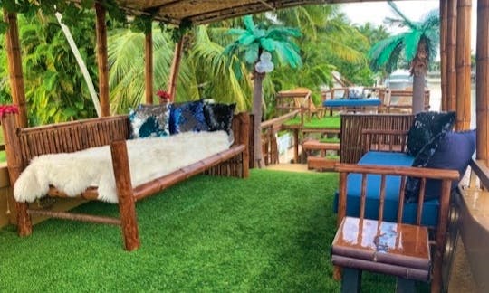 Cozy grass in VIP lounge with water misters for tropical cooling.