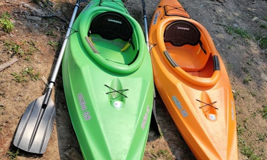 Orange 10-foot long sit-in kayak. (kayak on the right). Comes with paddle. Kayak has a built-in drink holder in front and built-in cooler in back.