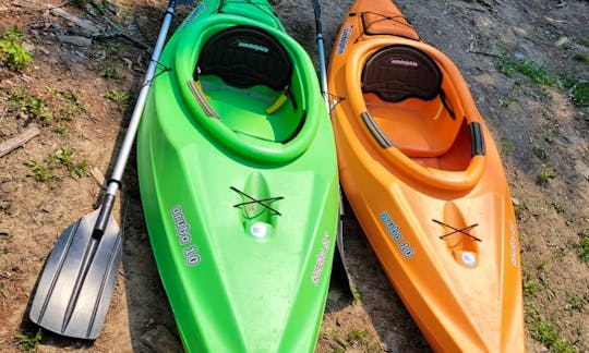 Orange 10-foot long sit-in kayak. (kayak on the right). Comes with paddle. Kayak has a built-in drink holder in front and built-in cooler in back.