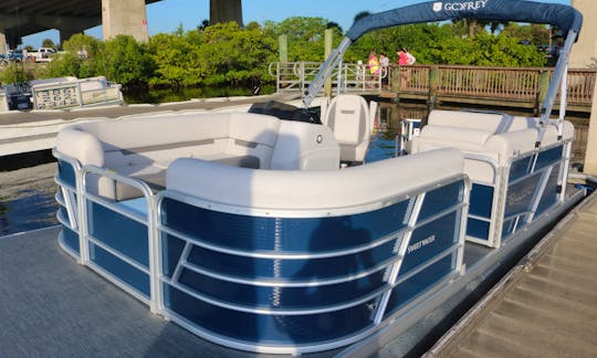 Elegant Godfrey Pontoon Boat with a bimini-top for shade.