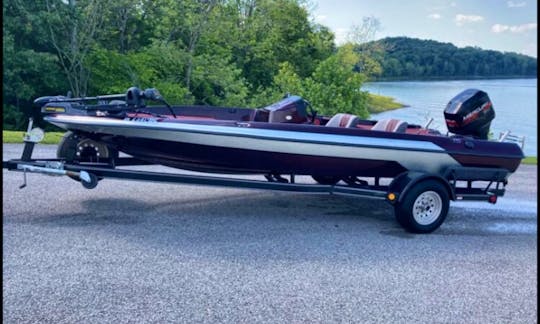 Bass boat equipped with trolling motor, two Garmin fish finders, and live well.
