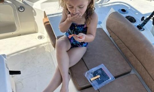 This little boater is enjoying her snack in the shade