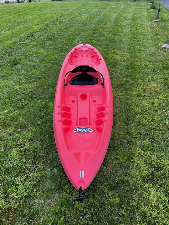 Un kayak rojo brillante de 10 pies para sentarse en la parte superior, convenientemente ubicado cerca del río Brandywine